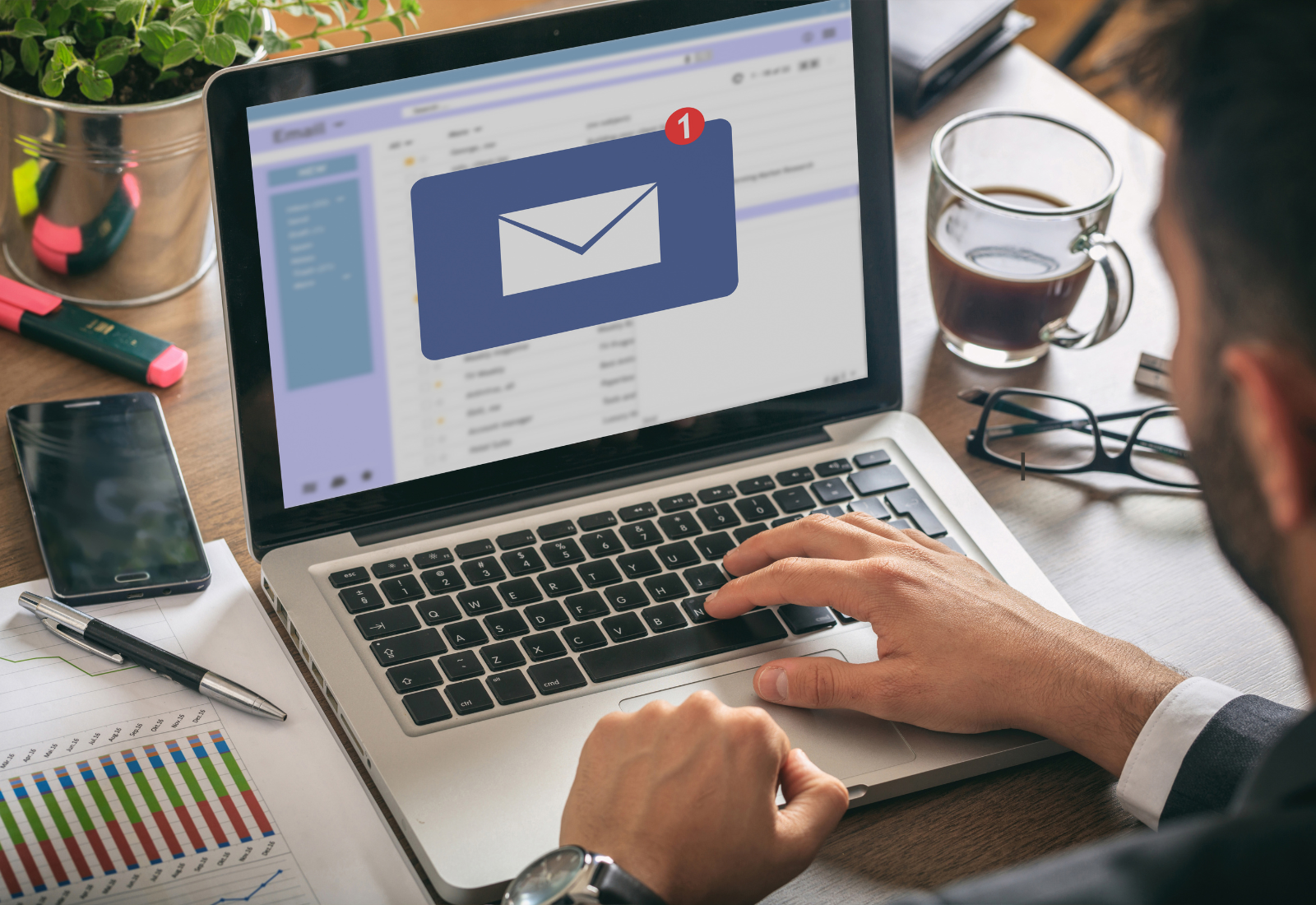 Image of a person typing on a laptop with an email on the screen