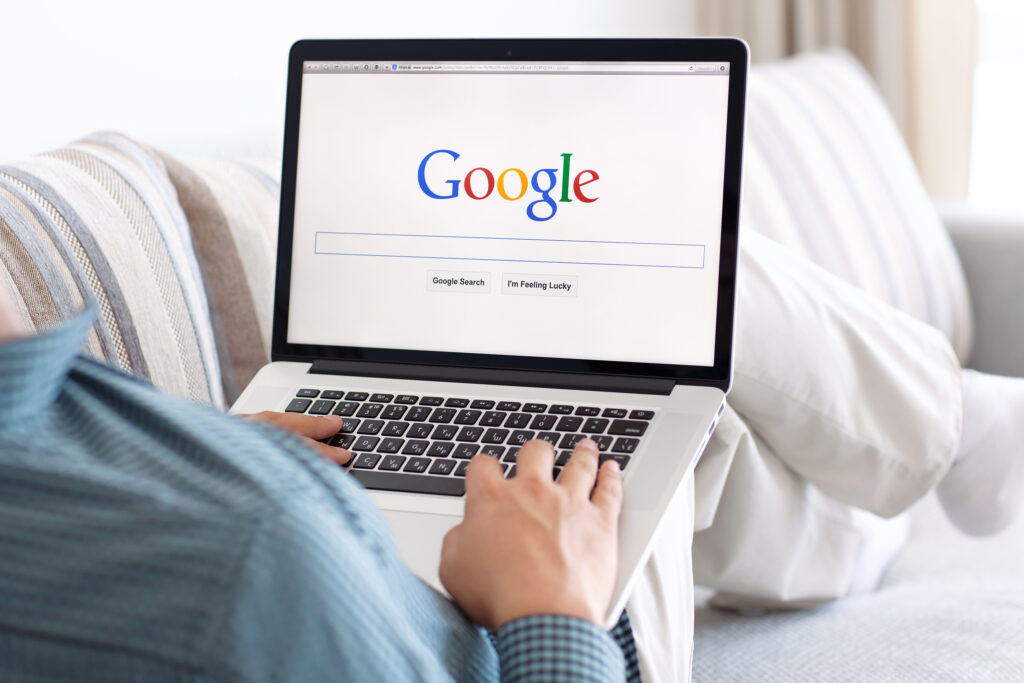 Image of a person using a computer with Google open on the screen